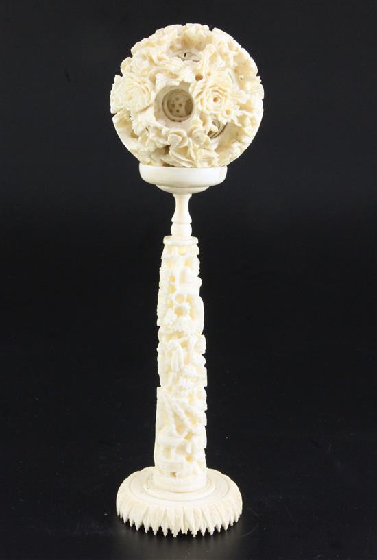 A Chinese ivory concentric puzzle ball and stand, early 20th century, ball 6.7cm, total height 23cm
